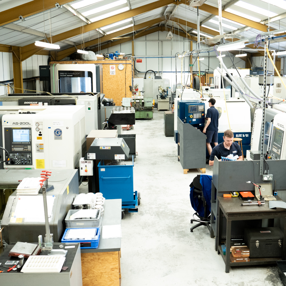 Bomic precision engineering workshop showing several large machines and 2 men operating machines