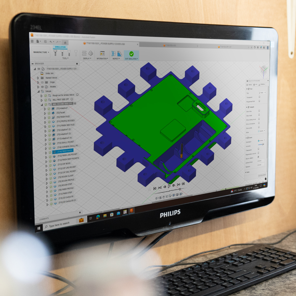 Green and blue CAD CAM precision engineering drawing shown on Philips computer screen