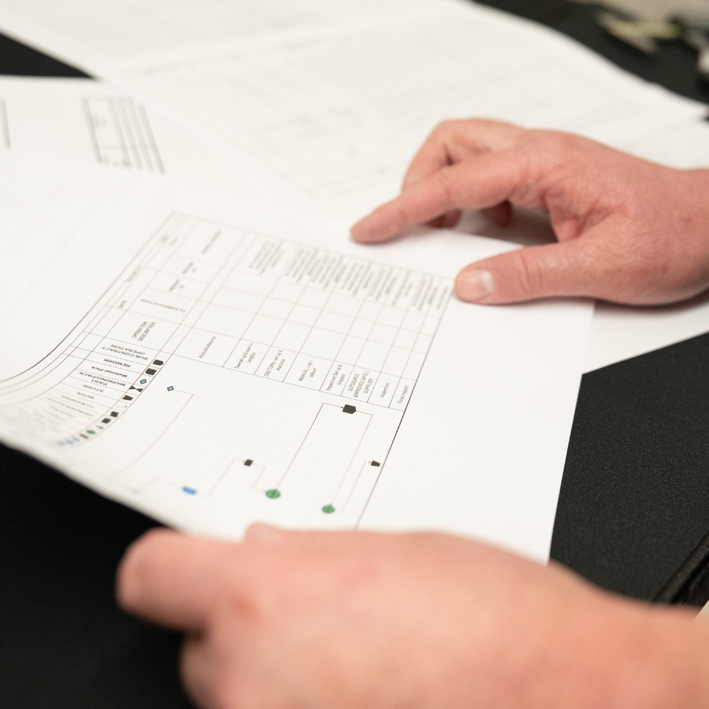 2 hands holding precision engineering inspection paperwork