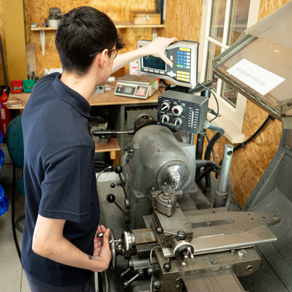 side view or man operating a precision engineering machine in workshop